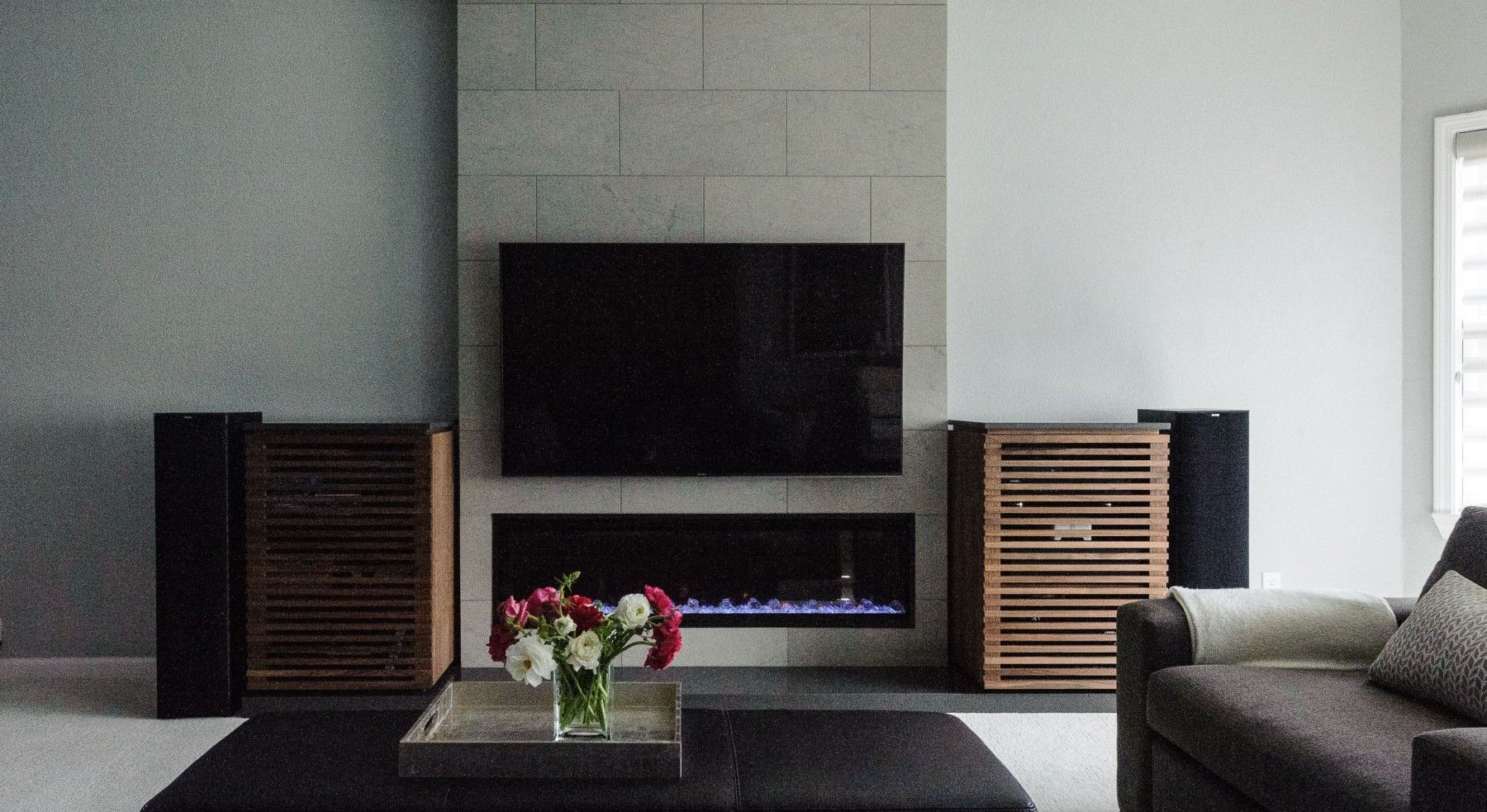 Refined living room with stone fireplace, custom wood cabinetry, and layered furnishings